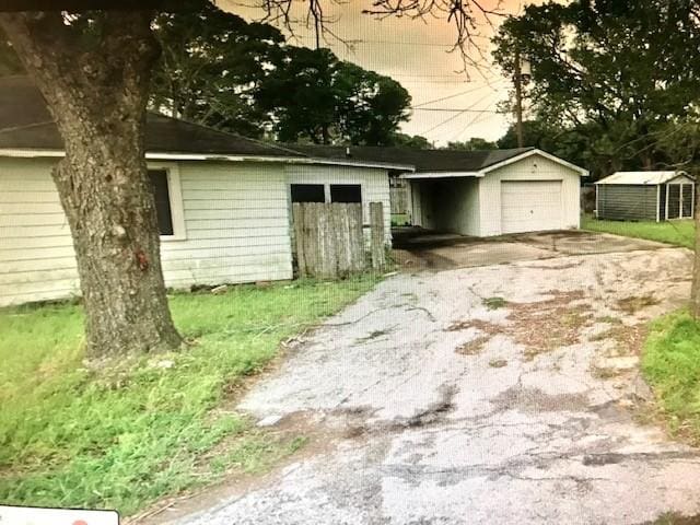 3417 Doris St, Bay City, TX 77414 - garage featuring asphalt driveway, a detached garage, and a storage unit