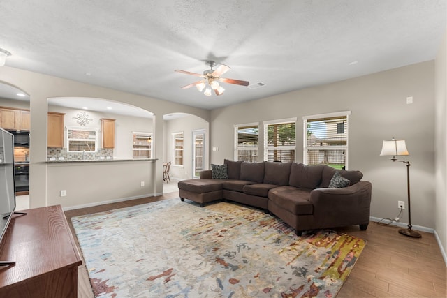 31820 Forest Oak Ln, Conroe, TX 77385 - living area featuring arched walkways, ceiling fan, and light wood-style flooring