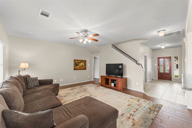 31820 Forest Oak Ln, Conroe, TX 77385 - living area featuring light wood finished floors, a ceiling fan, stairs, and arched walkways