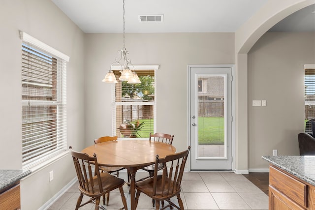 31820 Forest Oak Ln, Conroe, TX 77385 - dining room featuring light tile patterned flooring, arched walkways, and a chandelier