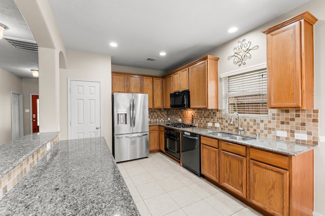 31820 Forest Oak Ln, Conroe, TX 77385 - kitchen featuring backsplash, black appliances, light stone countertops, light tile patterned floors, and recessed lighting