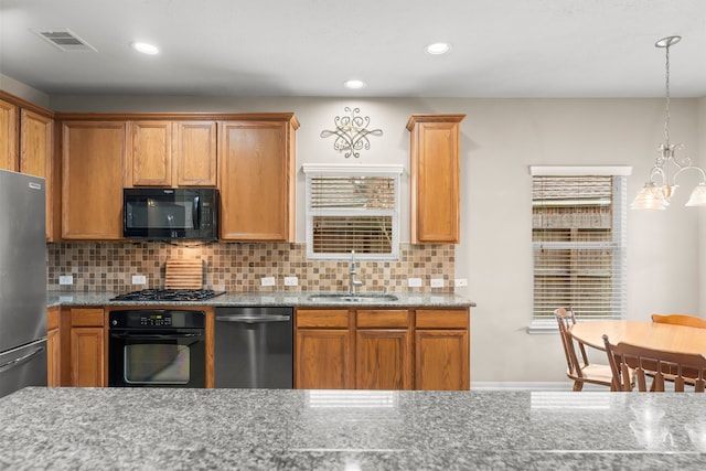 31820 Forest Oak Ln, Conroe, TX 77385 - kitchen with black appliances, light stone countertops, decorative backsplash, recessed lighting, and a chandelier