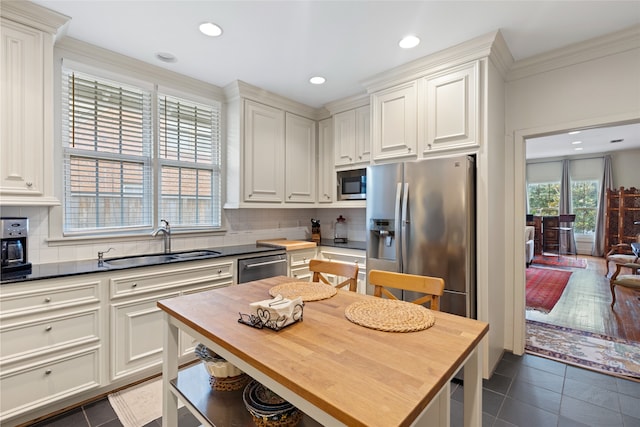 1311 Peden St, Houston, TX 77006 - kitchen with stainless steel appliances, wood counters, decorative backsplash, crown molding, and recessed lighting