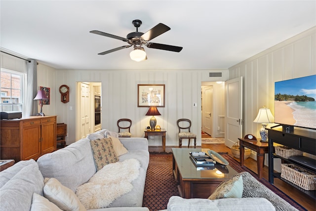 1311 Peden St, Houston, TX 77006 - living area featuring wood finished floors, ceiling fan, and a decorative wall