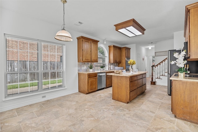 1711 Alcorn Bayou Dr, Sugar Land, TX 77479 - kitchen with dishwasher, brown cabinetry, a center island, decorative backsplash, and decorative light fixtures