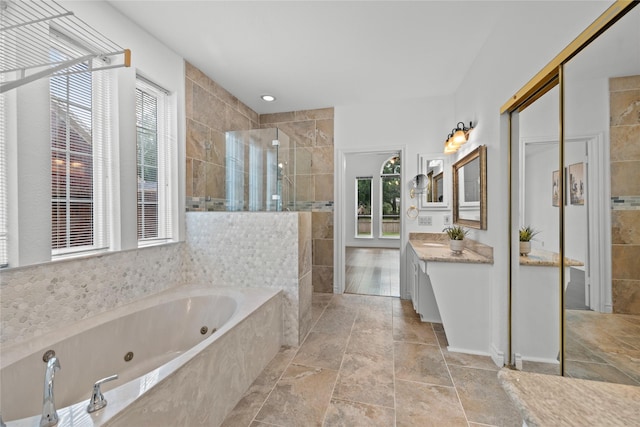 1711 Alcorn Bayou Dr, Sugar Land, TX 77479 - bathroom with vanity, walk in shower, a tub with jets, stone finish flooring, and tile walls