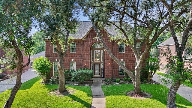1711 Alcorn Bayou Dr, Sugar Land, TX 77479 - view of front of property featuring brick siding, a front lawn, and a shingled roof
