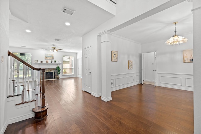 1711 Alcorn Bayou Dr, Sugar Land, TX 77479 - entrance foyer with a ceiling fan, a fireplace, dark wood-style flooring, recessed lighting, and wainscoting