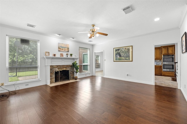 1711 Alcorn Bayou Dr, Sugar Land, TX 77479 - unfurnished living room featuring ceiling fan, ornamental molding, healthy amount of natural light, a fireplace, and wood finished floors