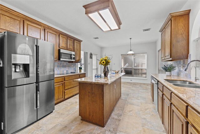 1711 Alcorn Bayou Dr, Sugar Land, TX 77479 - kitchen with stainless steel appliances, stone tile floors, a kitchen island, brown cabinets, and tasteful backsplash