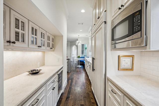 3001 Tangley Rd, West University Place, TX 77005 - kitchen with stainless steel microwave, dark wood-style floors, glass insert cabinets, light stone countertops, and tasteful backsplash