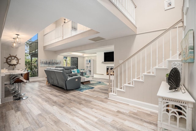3611 18th St N, Texas City, TX 77590 - living room featuring wood finished floors, stairway, a high ceiling, a chandelier, and a fireplace with raised hearth