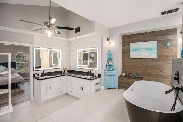 3611 18th St N, Texas City, TX 77590 - ensuite bathroom featuring a freestanding bath, wood walls, double vanity, a ceiling fan, and lofted ceiling