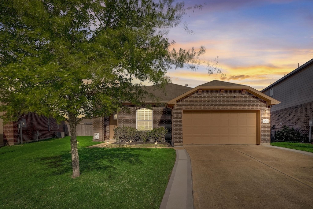 3122 Lodgemist Ln, Dickinson, TX 77539 - view of front of house featuring brick siding, driveway, a garage, and a lawn