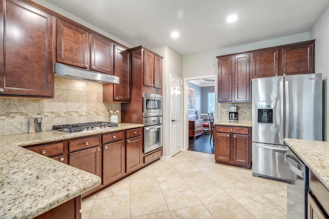 3602 Buchanan Hill Ln, Katy, TX 77494 - kitchen featuring stainless steel appliances, under cabinet range hood, decorative backsplash, light stone counters, and recessed lighting