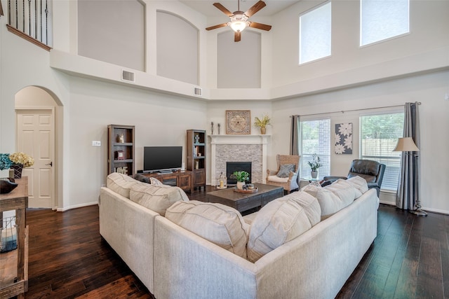3602 Buchanan Hill Ln, Katy, TX 77494 - living room with a towering ceiling, ceiling fan, dark wood finished floors, a stone fireplace, and arched walkways