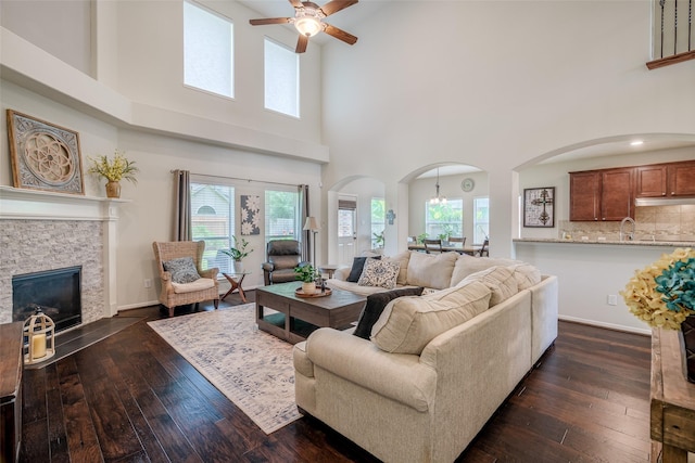 3602 Buchanan Hill Ln, Katy, TX 77494 - living area with arched walkways, a ceiling fan, a towering ceiling, healthy amount of natural light, and dark wood-style floors