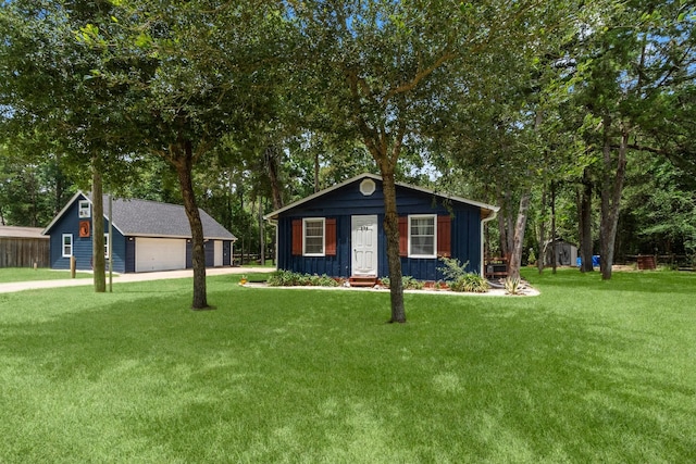 236 Fern, Livingston, TX 77351 - view of front of house featuring board and batten siding, an outdoor structure, a detached garage, and a front yard