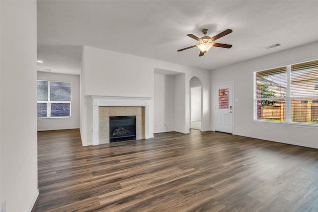 3510 Orchard Valley Ln, Spring, TX 77386 - unfurnished living room with a ceiling fan, arched walkways, dark wood finished floors, and plenty of natural light