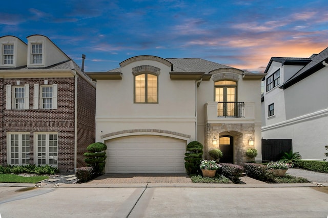 6310 Hermann Lake Dr, Houston, TX 77021 - french country style house with a balcony, driveway, stucco siding, stone siding, and a garage