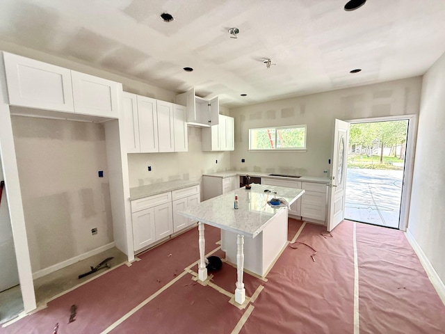 201 Davis St, Bryan, TX 77801 - kitchen featuring white cabinetry, a kitchen island, a breakfast bar, and recessed lighting
