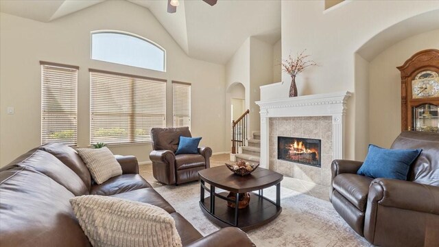 14822 Meridian Park Ln, Humble, TX 77396 - carpeted living room featuring arched walkways, plenty of natural light, a tile fireplace, a ceiling fan, and high vaulted ceiling