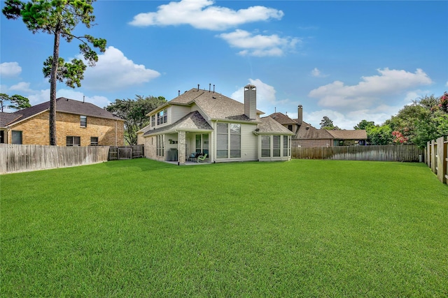 17003 Buffalo Peak Ct, Humble, TX 77346 - rear view of house featuring a fenced backyard, brick siding, and a chimney