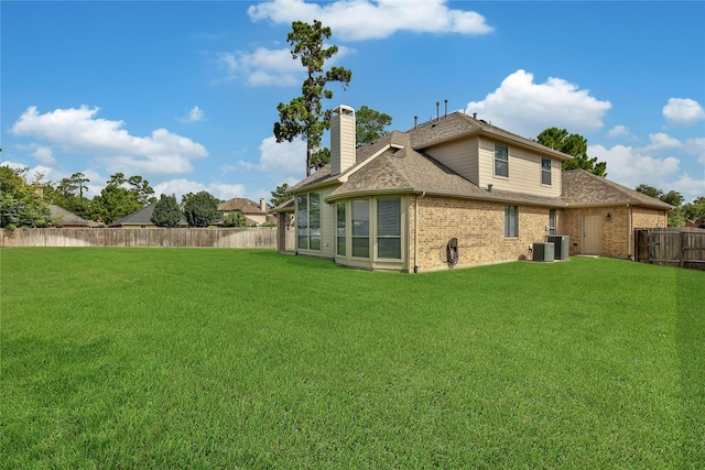 17003 Buffalo Peak Ct, Humble, TX 77346 - back of house featuring a fenced backyard, a chimney, brick siding, and roof with shingles