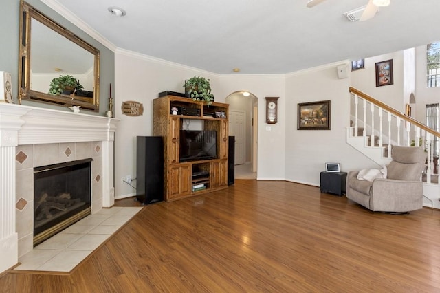10415 Claybrook Dr, Houston, TX 77089 - living room featuring wood finished floors, arched walkways, stairway, a fireplace, and ceiling fan