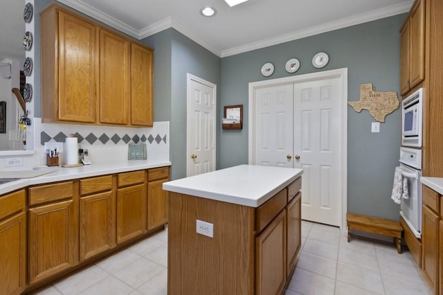 10415 Claybrook Dr, Houston, TX 77089 - kitchen with white appliances, brown cabinetry, backsplash, ornamental molding, and light countertops