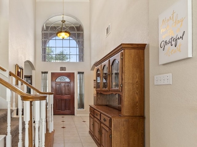10415 Claybrook Dr, Houston, TX 77089 - foyer entrance featuring a high ceiling, arched walkways, light tile patterned floors, and stairway