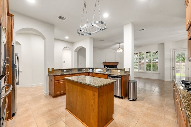 21510 Briar Landing Ln, Katy, TX 77450 - kitchen with stainless steel appliances, a kitchen island, ceiling fan, dark stone counters, and light tile patterned flooring