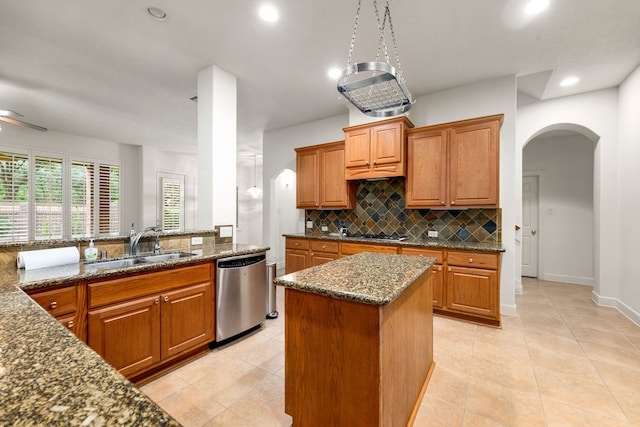21510 Briar Landing Ln, Katy, TX 77450 - kitchen with appliances with stainless steel finishes, tasteful backsplash, brown cabinetry, arched walkways, and recessed lighting
