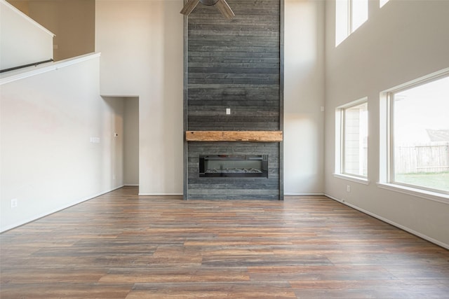 3022 Darlington Ct, Katy, TX 77494 - unfurnished living room featuring a towering ceiling, healthy amount of natural light, a large fireplace, and wood finished floors