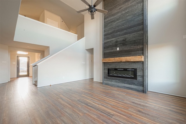 3022 Darlington Ct, Katy, TX 77494 - unfurnished living room featuring high vaulted ceiling, stairs, a ceiling fan, wood finished floors, and a large fireplace