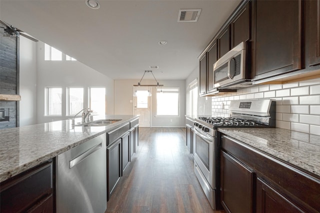 3022 Darlington Ct, Katy, TX 77494 - kitchen featuring appliances with stainless steel finishes, wood finished floors, dark brown cabinetry, recessed lighting, and tasteful backsplash