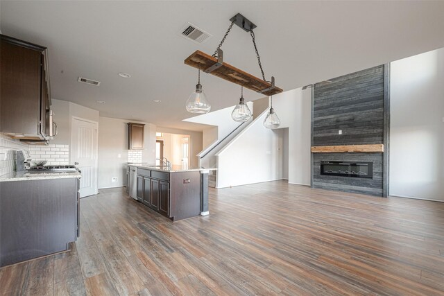 3022 Darlington Ct, Katy, TX 77494 - kitchen featuring open floor plan, wood finished floors, a large fireplace, backsplash, and recessed lighting