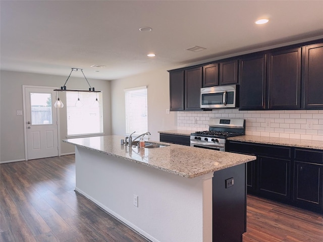3022 Darlington Ct, Katy, TX 77494 - kitchen with appliances with stainless steel finishes, tasteful backsplash, an island with sink, dark wood finished floors, and recessed lighting