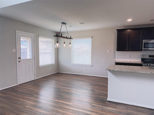 3022 Darlington Ct, Katy, TX 77494 - kitchen featuring stainless steel appliances, light stone countertops, backsplash, dark wood finished floors, and recessed lighting