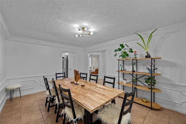 8519 Rebawood Dr, Humble, TX 77346 - dining space featuring light tile patterned floors, crown molding, a chandelier, wainscoting, and a decorative wall