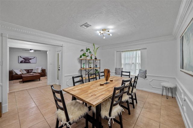8519 Rebawood Dr, Humble, TX 77346 - dining area with light tile patterned flooring, a decorative wall, crown molding, and a wainscoted wall