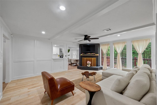 8519 Rebawood Dr, Humble, TX 77346 - living room with a decorative wall, a ceiling fan, a fireplace, light wood-type flooring, and recessed lighting