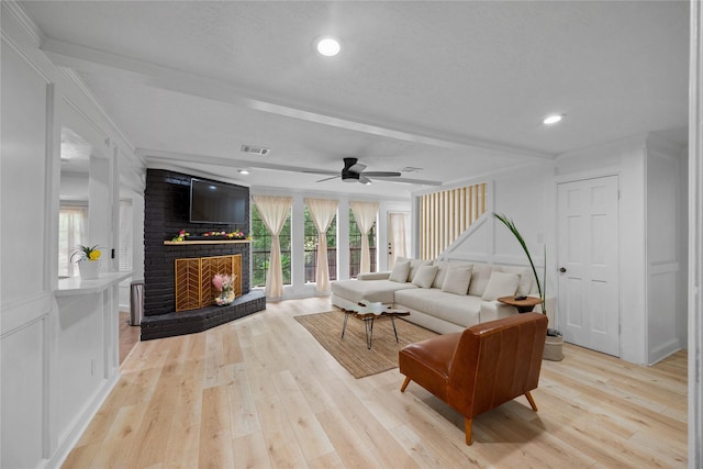 8519 Rebawood Dr, Humble, TX 77346 - living area featuring a brick fireplace, ceiling fan, light wood finished floors, recessed lighting, and ornamental molding