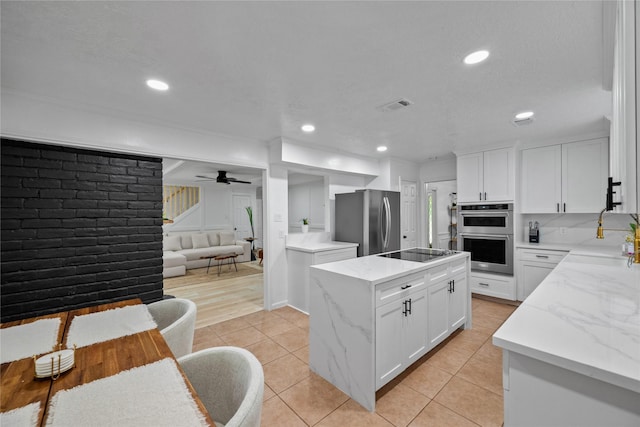 8519 Rebawood Dr, Humble, TX 77346 - kitchen featuring stainless steel appliances, a kitchen island, light tile patterned floors, white cabinets, and recessed lighting
