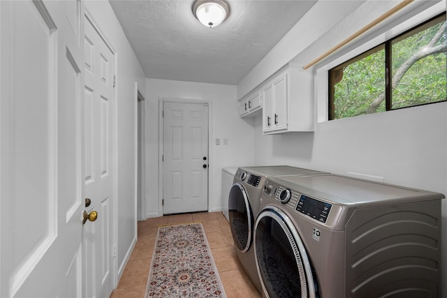 8519 Rebawood Dr, Humble, TX 77346 - washroom with washer and clothes dryer, cabinet space, light tile patterned floors, and a textured ceiling