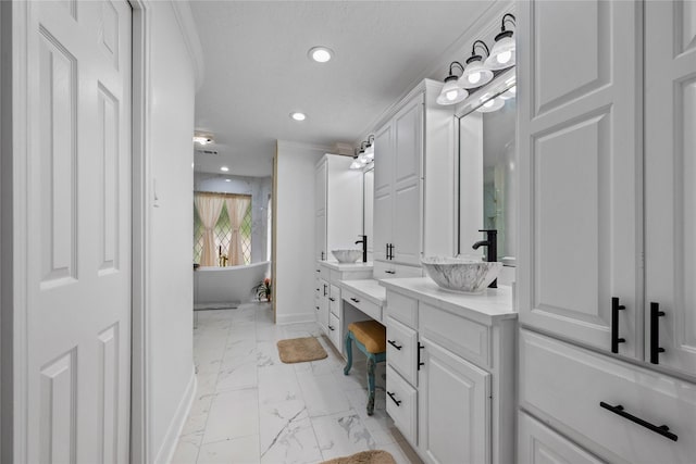 8519 Rebawood Dr, Humble, TX 77346 - full bath featuring marble look tiles, double vanity, a freestanding bath, recessed lighting, and crown molding
