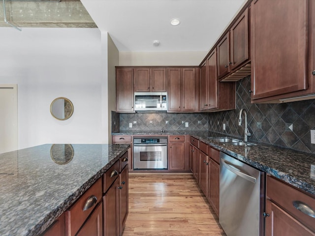 2700 Albany St Unit 3A, Houston, TX 77006 - kitchen with stainless steel appliances, light wood finished floors, dark stone countertops, and tasteful backsplash