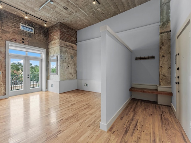 2700 Albany St Unit 3A, Houston, TX 77006 - unfurnished room with rail lighting, wood finished floors, a towering ceiling, and french doors