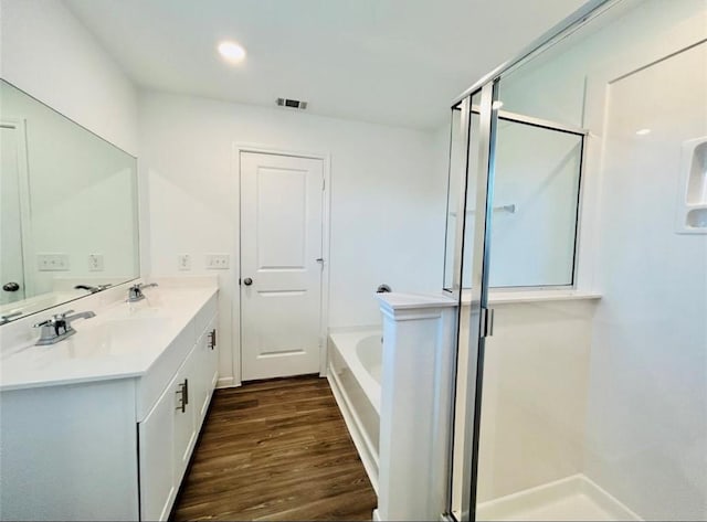 1009 Laguna Cove Dr, Katy, TX 77493 - bathroom with a shower stall, a garden tub, double vanity, wood finished floors, and recessed lighting