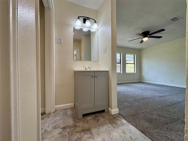 609 S Gray Ave, West Columbia, TX 77486 - bathroom with vanity, ceiling fan, a textured ceiling, and a textured wall